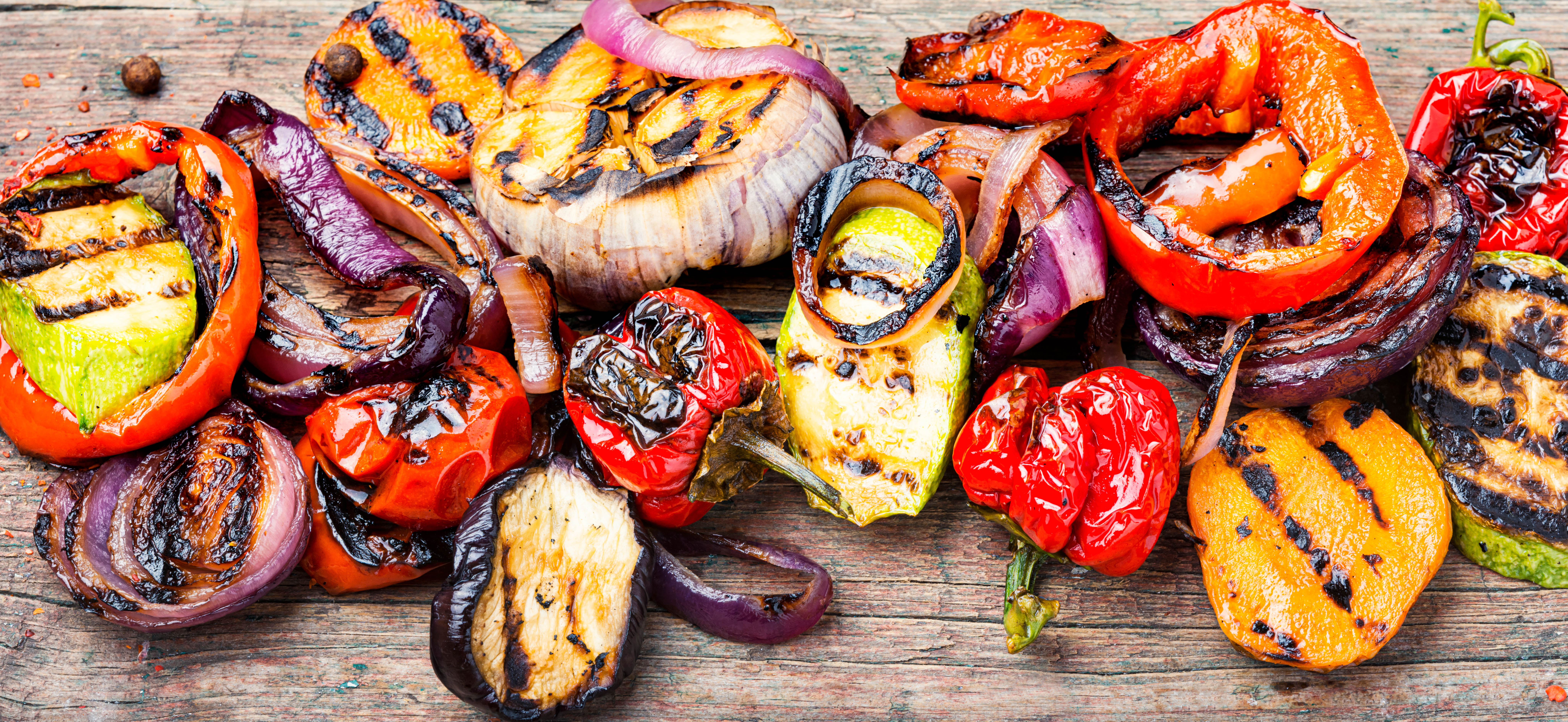Cutting board filled with grilled vegetables - including tomatoes, peppers, onions, zucchini, and more Cutting board filled with grilled vegetables - including tomatoes, peppers, onions, zucchini, and more